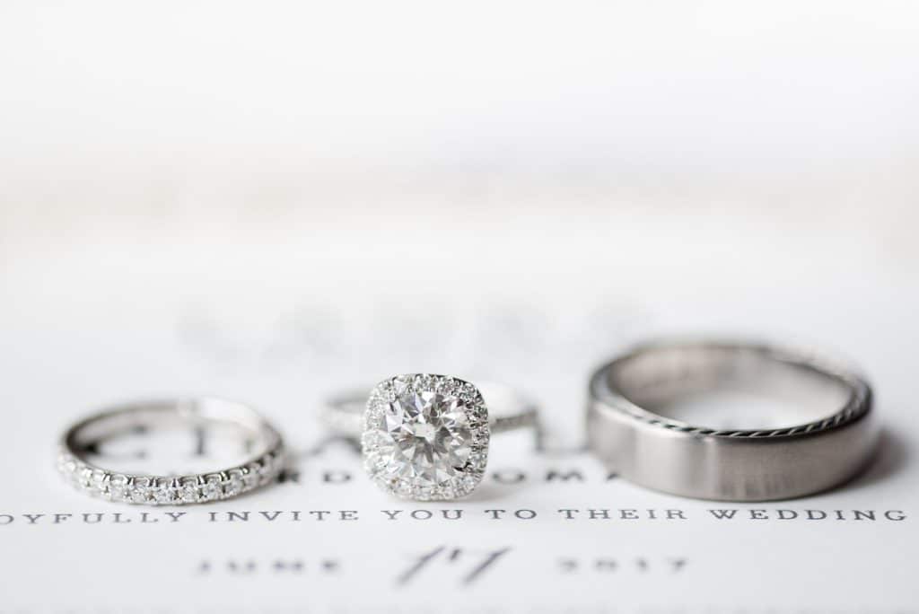 Wedding bands and engagement ring on wedding invitation