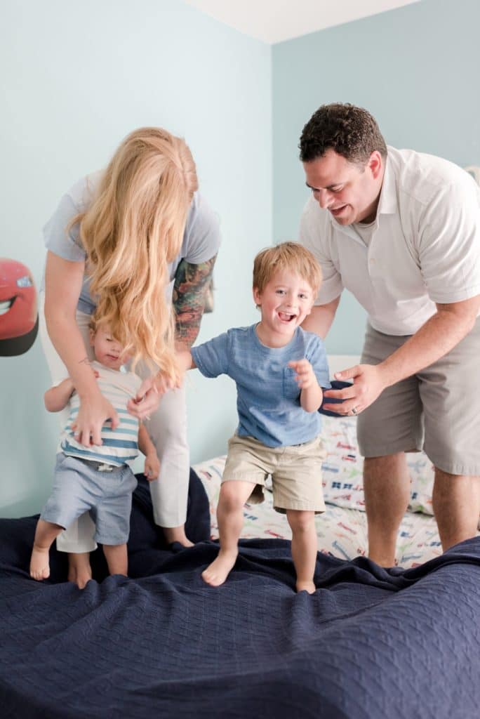 Family jumping on the bed together at home