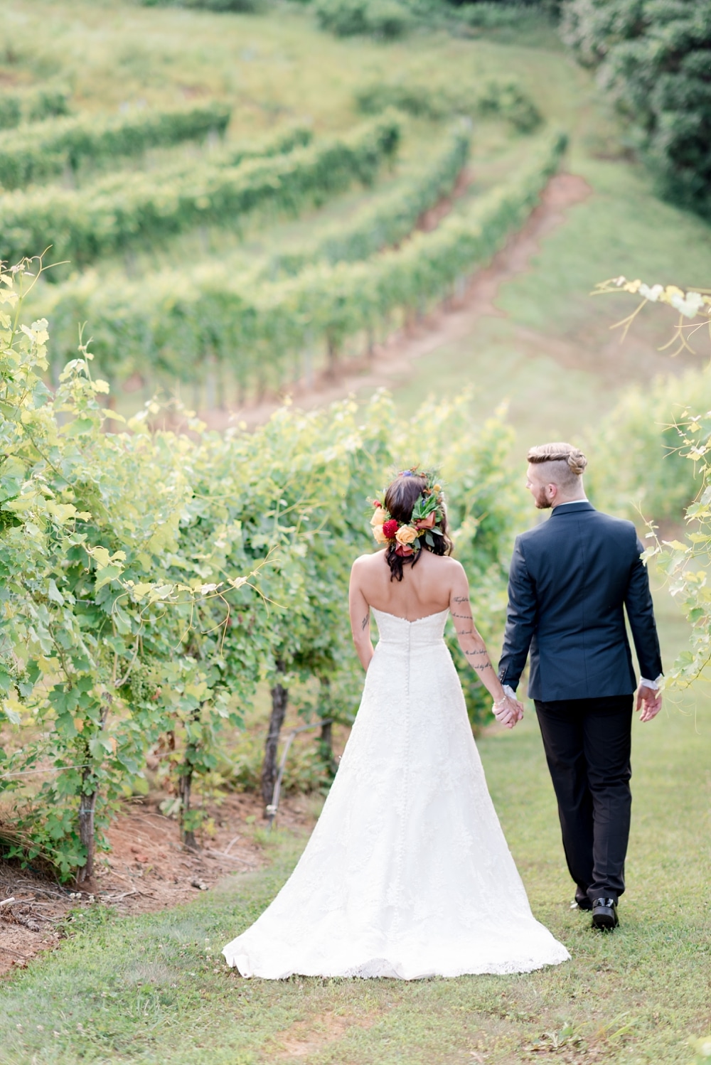 Bride and groom walking in vines at DelFosse Winery near Charlottesville