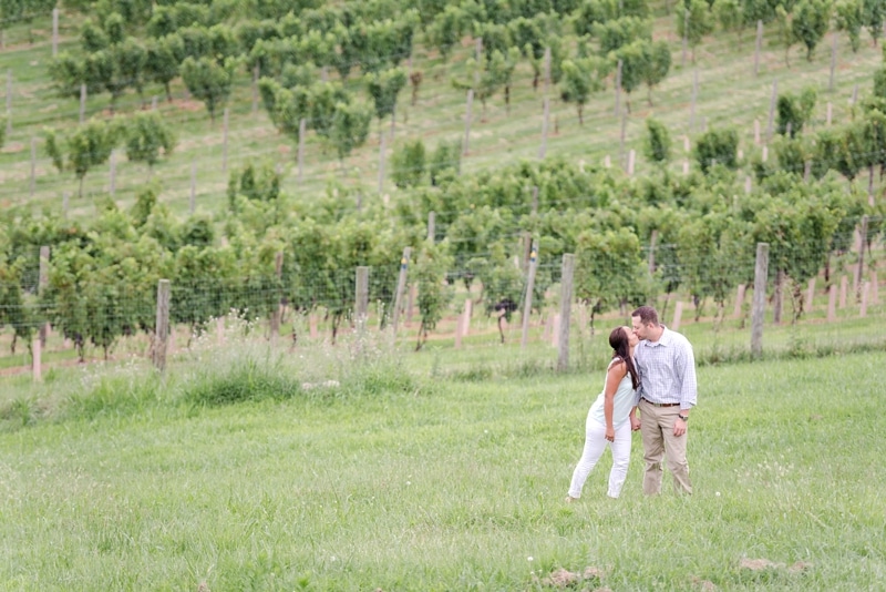 Couple kissing near vines of Blue Valley Vineyard and Winery in VA