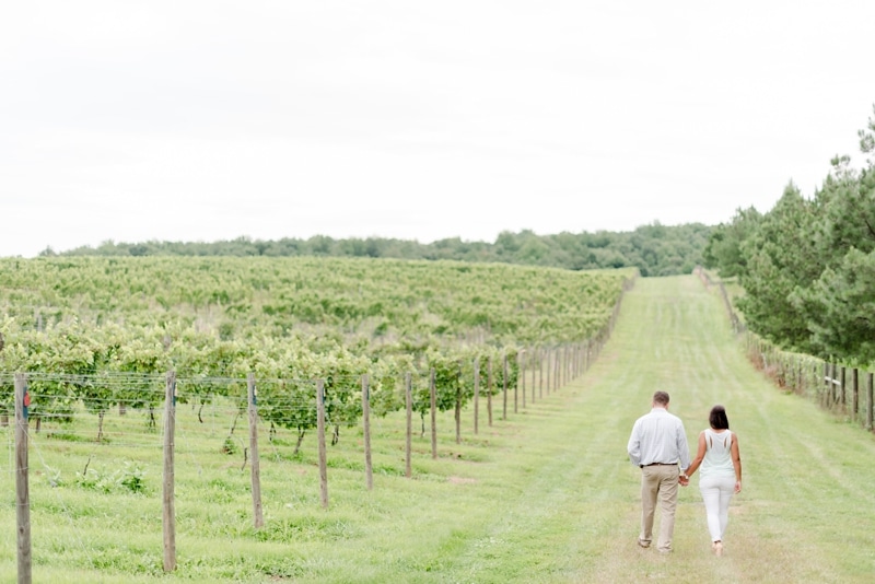 Couple walking during engagement photo session at Blue Valley Vineyard and Winery