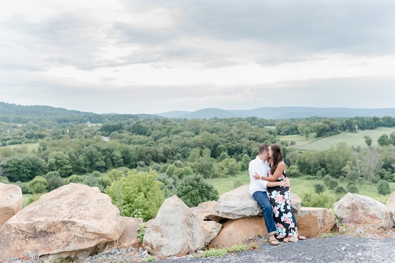 Couple sitting on rocks with beautiful views at Blue Valley Vineyard engagement session