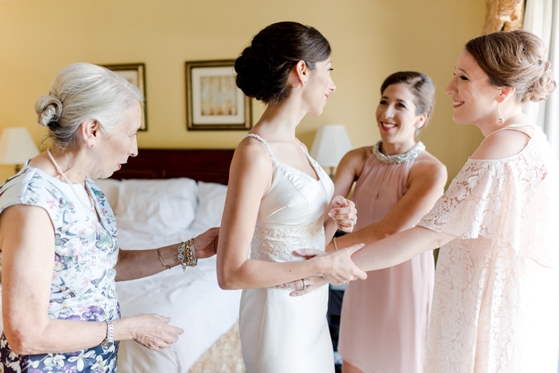 Bride with sisters and mom while getting ready for wedding