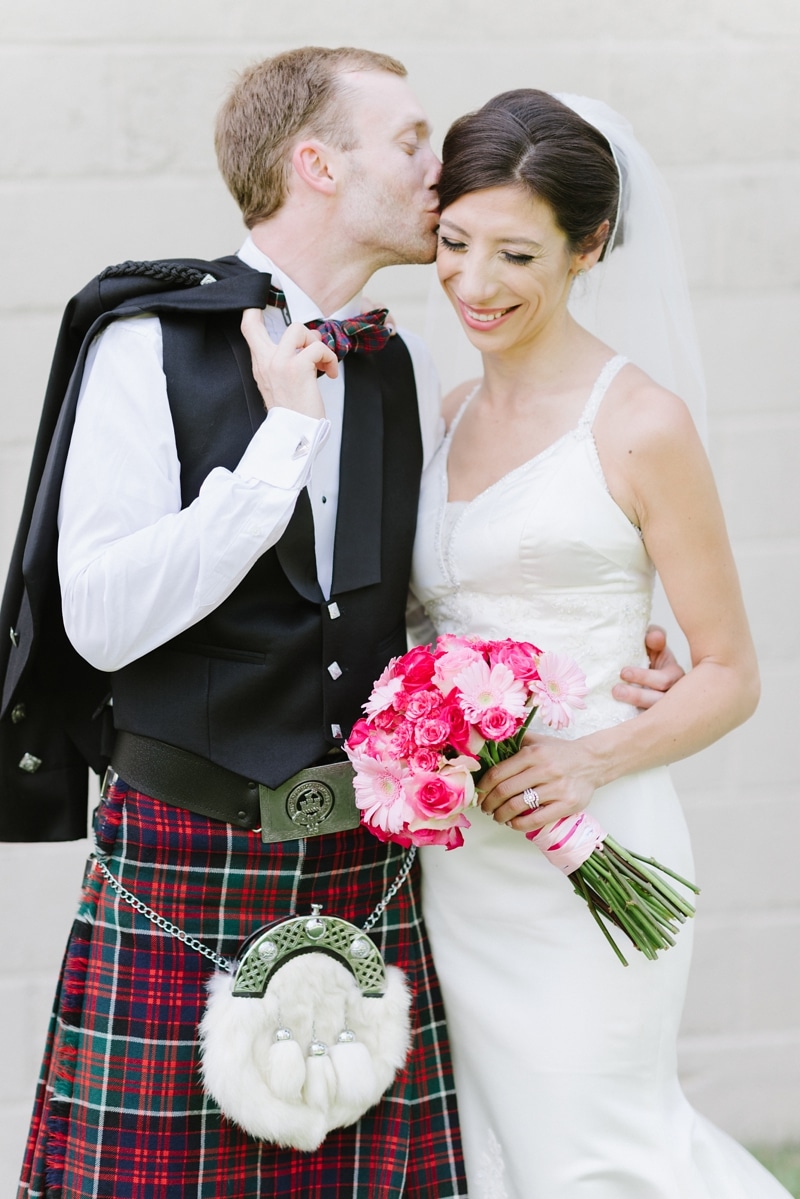 Groom in Scottish kilt and his bride during portraits on wedding day in Virginia