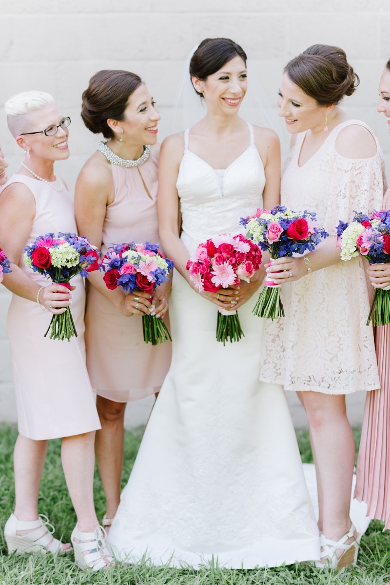 Bride and bridesmaids together smiling with blush colors