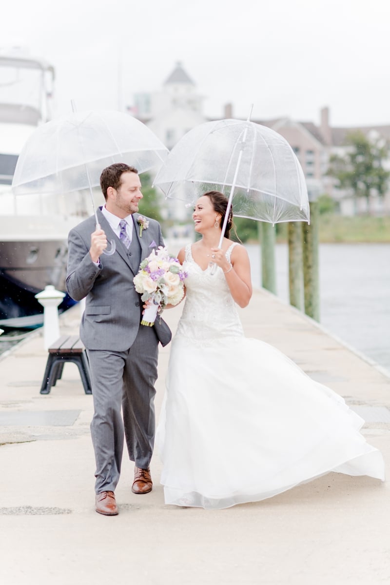 Bride and groom walking under umbrellas at Hyatt Regency Chesapeake Bay rainy wedding