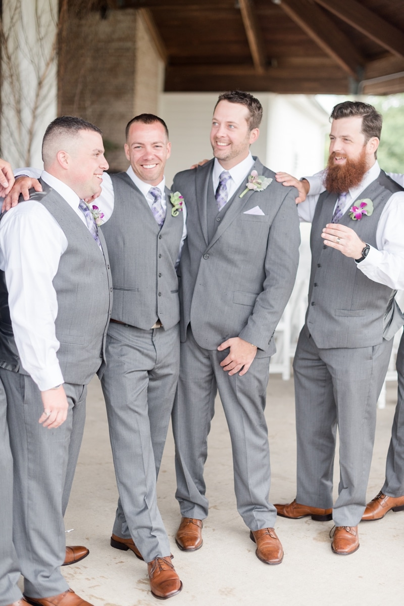 Groom and his guy friends laughing during portraits