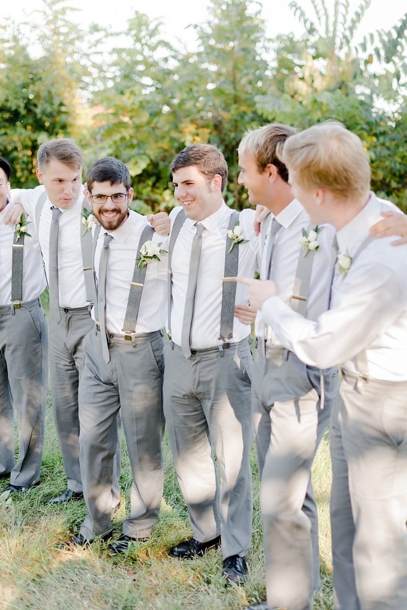 Groom and groomsmen laughing together before wedding