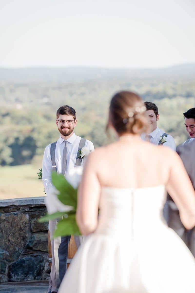 Groom sees bride during wedding ceremony walking down aisle