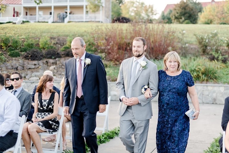 Groom walking down aisle with parents