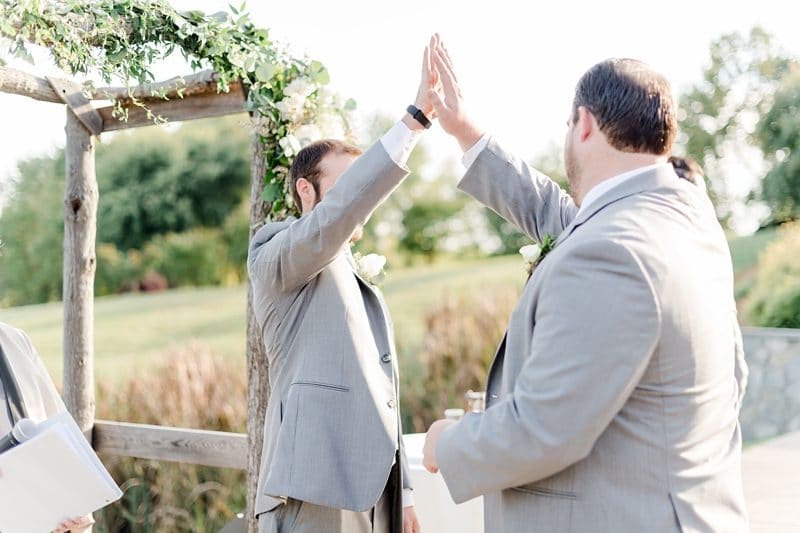 Groom high fiving brother during ceremony