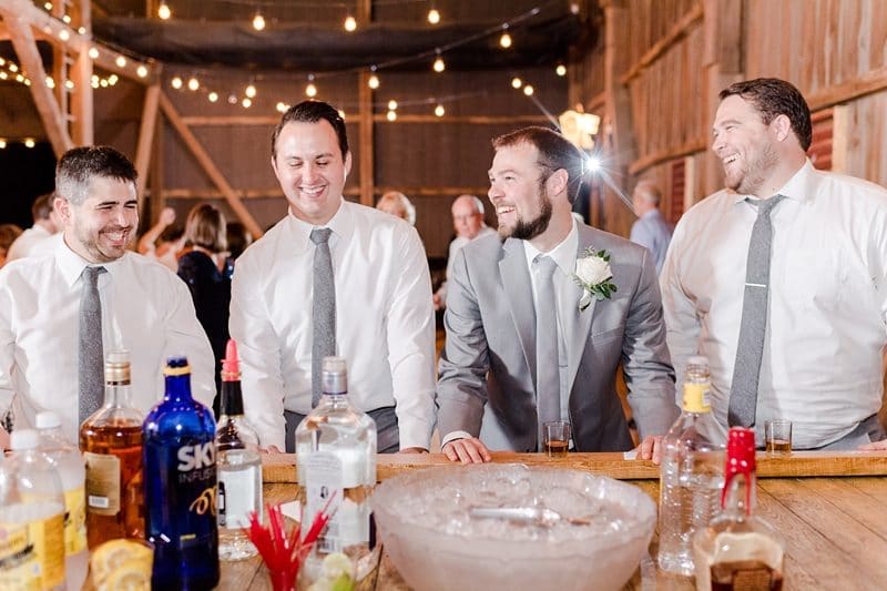 Groom and groomsmen at wedding reception with shotski