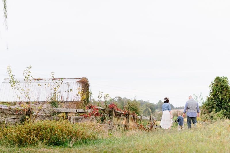 Family walking on farm during photo session in Fredericksburg VA 