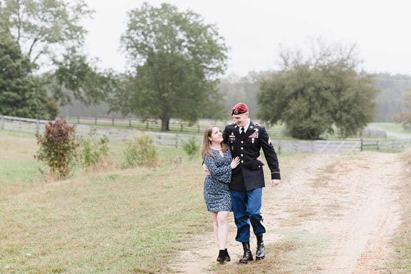 Engaged couple walking on farm in Fredericksburg VA