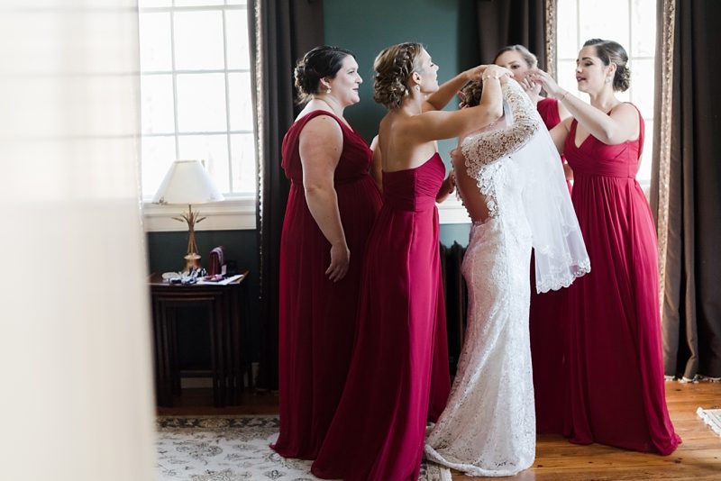 Bride and bridesmaids putting on veil