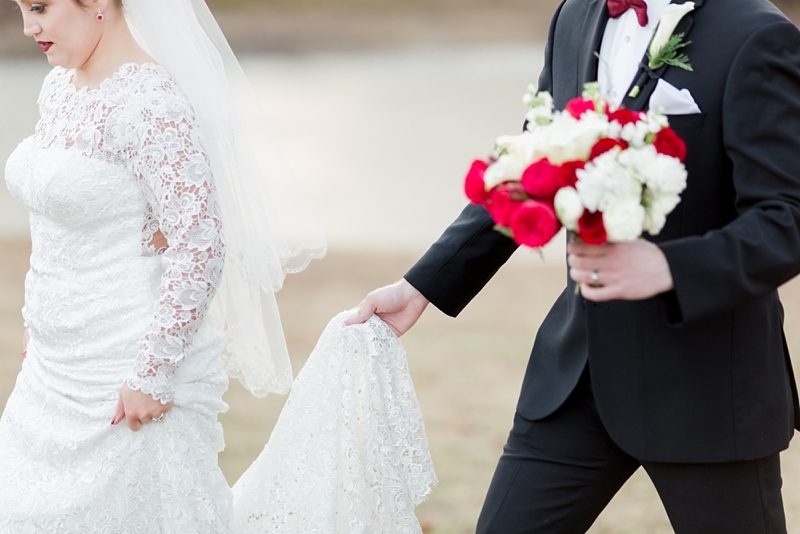 Groom holding bride's dress