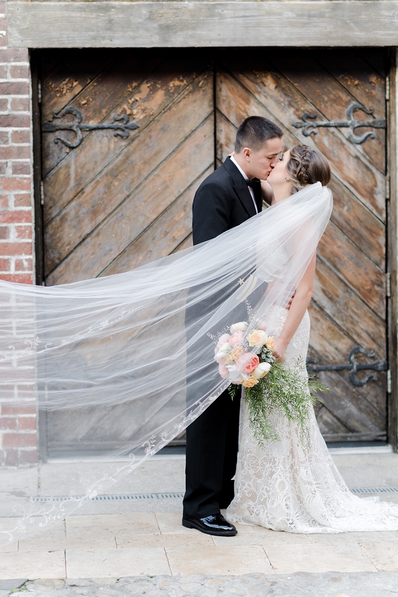 Bride and groom kissing with veil at Williamsburg Winery